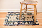 Early Peking rug fragment with tattered repeating pearl border and open ivory field.