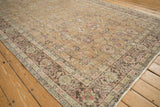 Angled perspective on the time-softened floral patterns of a vintage distressed Sparta rug.