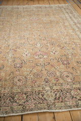 A low perspective on a distressed Sparta carpet reveals its time-softened floral pattern.
