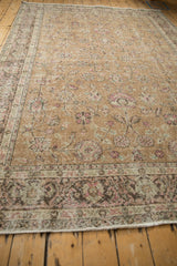 Perspective view of a distressed Turkish carpet's floral field and time-softened border.