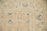 Detail of worn hand knotted Sparta rug with faded palmettes and navy blue vinery.