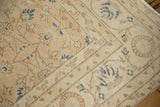 Distressed Sparta carpet close-up, worn sandy pile with navy blue floral motifs.