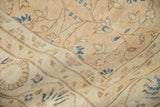Distressed Sparta carpet detail showing worn texture with dusty sandalwood and navy floral vinery.