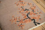 Art Deco rug, subtly embossed terracotta cherry blossoms and navy branches on dusty mauve.