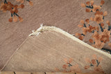 Antique Art Deco rug corner, dusty mauve pile, terracotta blossoms, and woven foundation.