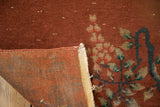 Antique Art Deco rug detail: copper floral pile, worn edge, and uneven reverse foundation.