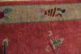 Stylized motifs on oxidized silver border and raspberry field of Art Deco rug.