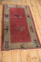 Close-up of Antique Chinese Art Deco rug corner, raspberry red field, ornate vase motif.