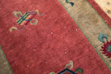 Detail of antique Art Deco runner showing raspberry field, multi-color cloudband motif, and beige border.