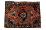 Antique Farahan Sarouk rug, dusty brick red field, floral medallion, vinery, and dark navy borders.
