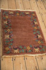 Antique Art Deco rug corner with scrolling vines, blossoms, mint green leaves on dusty copper.