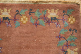 Detail of antique Art Deco rug's dusty copper pile with expressive green leaves and gold blossoms.
