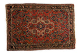 Vintage Persian Dargezine rug with a shadow medallion, stylized leaves, and a brick red field.