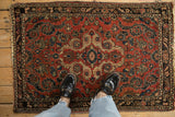 A person's view looking down at a vintage Dargezine rug's texture and scale.