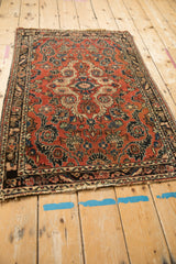 Angled view of the vintage Persian Dargezine rug, showing the time-worn texture and tattered lower edge.