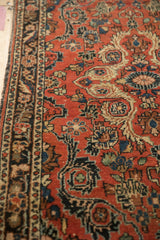Angled view of a vintage Persian rug's detailed floral sprays and machine-bound side.