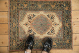 Vintage Tabriz mat shown for scale, detailing the central medallion and arabesque main border.