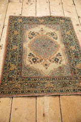 Traditional vintage Tabriz rug with a central medallion, viewed from an angle.