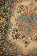 Detailed angled view of the arabesque border and scalloped medallion on a vintage Persian Tabriz rug.