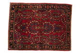 Vintage Sarouk rug fragment with a thousand-flower design on a cherry red field and a navy border.