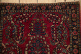 Sapphire blue and ivory details in the floral border of a vintage cherry red Sarouk rug.