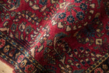 Intricate thousand flower design on the dense, cherry red pile of a vintage Sarouk rug.