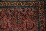 Vintage Lilihan rug corner showing raspberry floral field and sapphire blue palmette border.