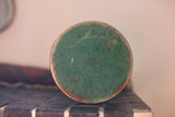 Circular green base with aged metal and attractive patina on antique shaving mirror.