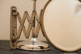 Detail of the unique expandable arm, displaying aged metal patina on the antique shaving mirror.