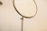 Detail of a vintage shaving mirror's curved metal frame with visible patina.