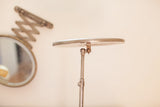 Patinaed metal base and pole of the antique standing mirror with expandable mechanism.