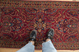 Standing view showing the texture and dense floral pattern of a vintage Persian Sarouk rug.