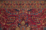 Serrated leaf and meandering vine borders of a vintage Sarouk in raspberry, blue, and gold.