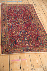 Angled view of a vintage Sarouk rug runner's raspberry and blue thousand-flower pattern.