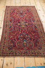 Angled view of a vintage Sarouk runner's raspberry field and dense floral sprays.