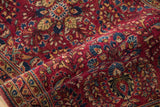 Rich raspberry and sapphire blue floral motifs on the vintage Persian Sarouk's evenly worn pile.