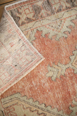 Distressed vintage Oushak rug pile texture with exposed foundation and side selvage.