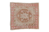 A distressed vintage Oushak square rug with a starburst medallion in copper, pink, and ivory tones.