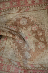 The low, distressed pile of a hand-knotted Oushak rug with visible knot heads.