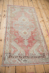 Lower border detail of the distressed Oushak rug with blush and silver hues.