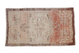 Distressed vintage Oushak runner with a faded medallion on a copper and sandalwood abrashed field.
