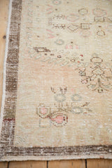 Close-up of the vintage Oushak's mostly even wear, exposed knot heads, and intact brown side cord.