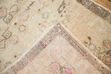The hand-knotted back and distressed pile of a vintage Oushak rug shown at the corner.
