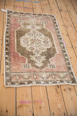 The intact side cord selvage and worn pile on a vintage distressed Turkish Oushak rug.