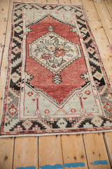 Distressed Oushak rug with serrated leaf border, pale seafoam spandrel, and visible even wear.