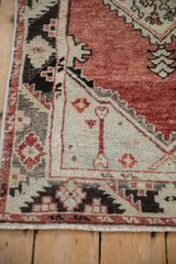 Distressed Oushak rug corner, pale seafoam spandrel, serrated brick red border.