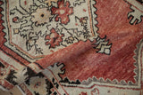 Distressed brick red field and serrated geometric border detail on a vintage Oushak rug.