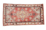 Vintage distressed Oushak rug with a geometric medallion in faded brick red, saffron, and charcoal.