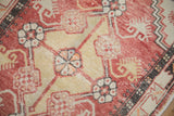 Worn texture of a distressed Oushak rug showing floral motifs in abrashed red and saffron yellow.