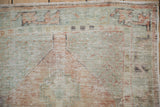 The time-worn texture of a vintage Oushak rug with visible knot heads in seafoam green and sandalwood.